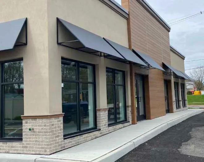 Gray rectractable awning installed on top of windows and door of an establishment in Eatontown, NJ